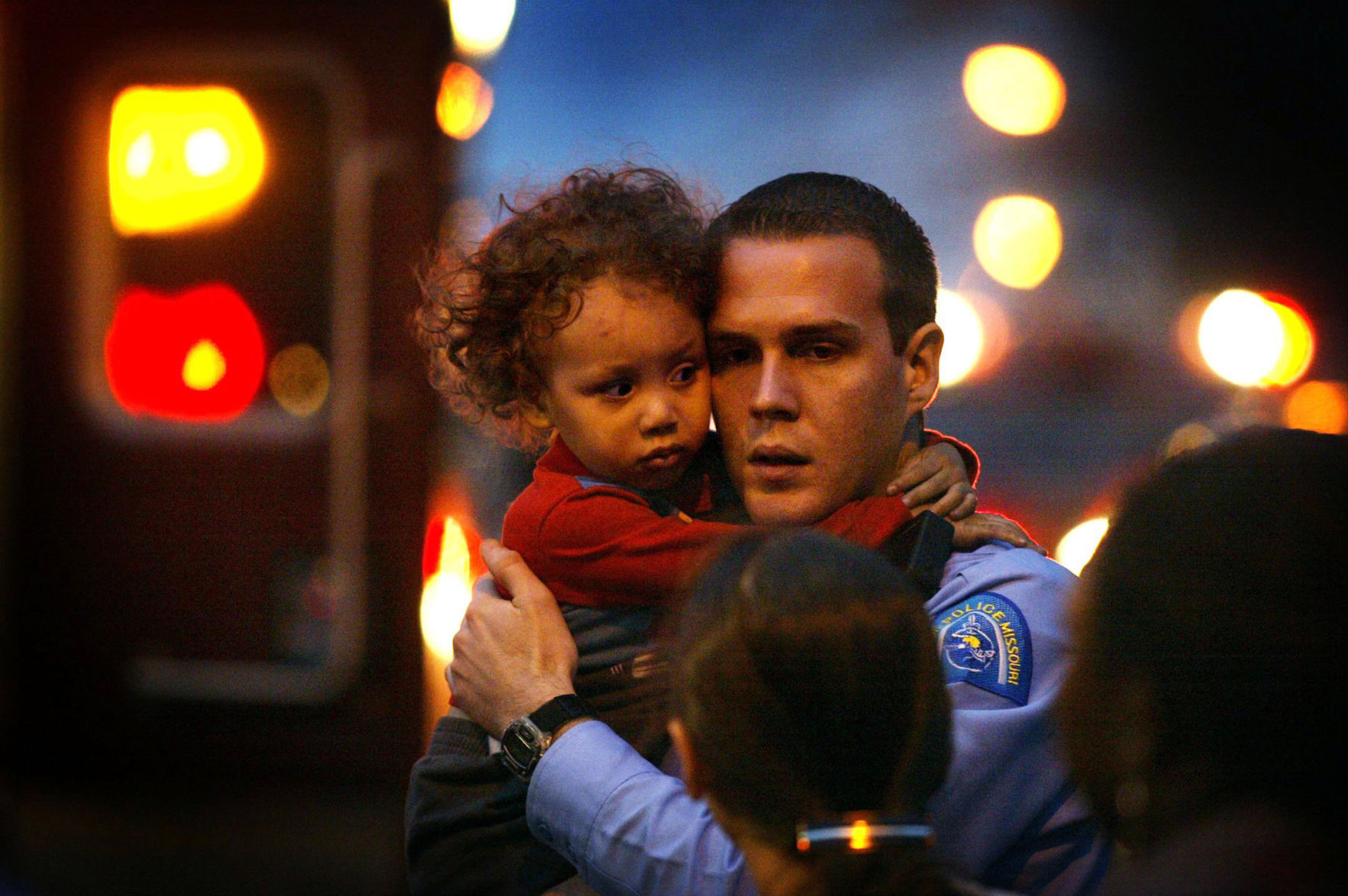 Police officer clutches young fire victim